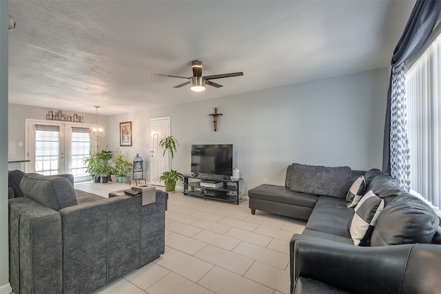 living room featuring ceiling fan, a textured ceiling, and french doors