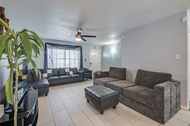 living room with a textured ceiling, light tile patterned floors, and ceiling fan