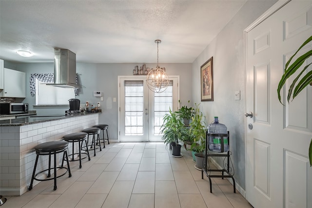 interior space featuring an inviting chandelier, plenty of natural light, and a textured ceiling