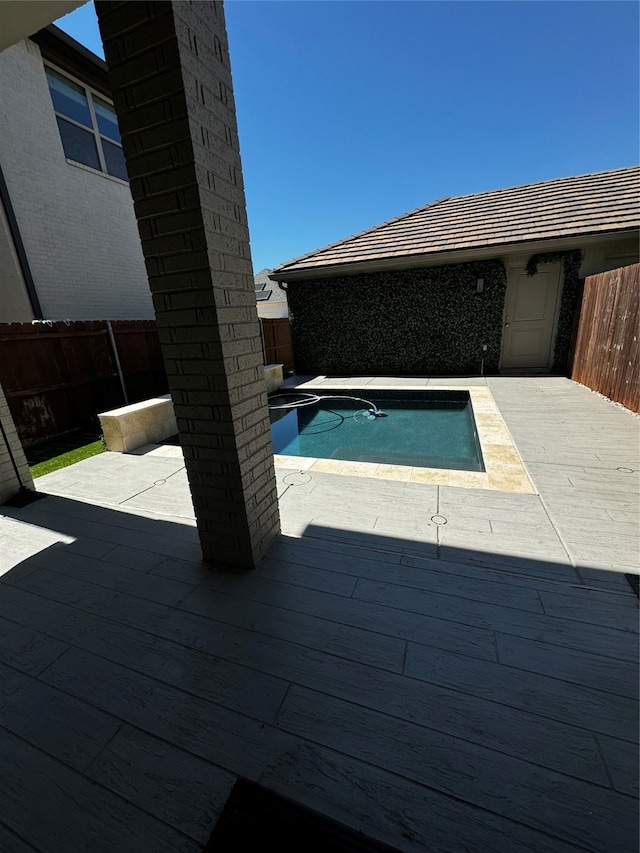 view of pool with a wooden deck and a patio area