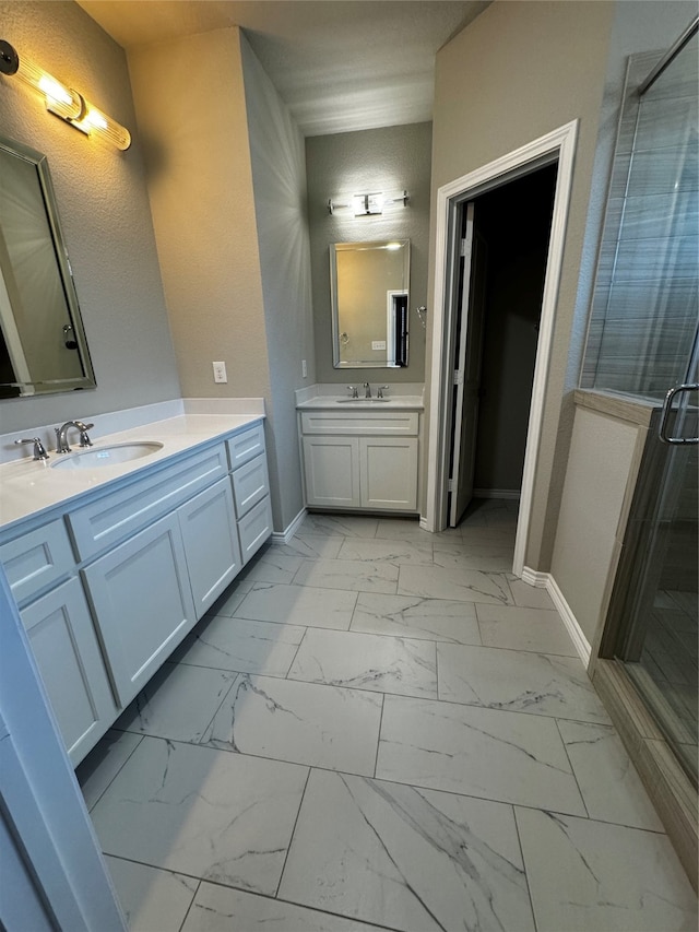 bathroom with a shower with shower door and vanity