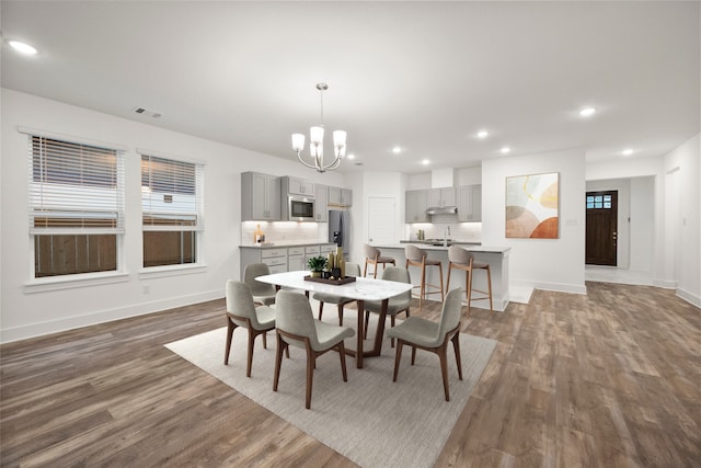 dining area featuring plenty of natural light, dark hardwood / wood-style floors, and a notable chandelier