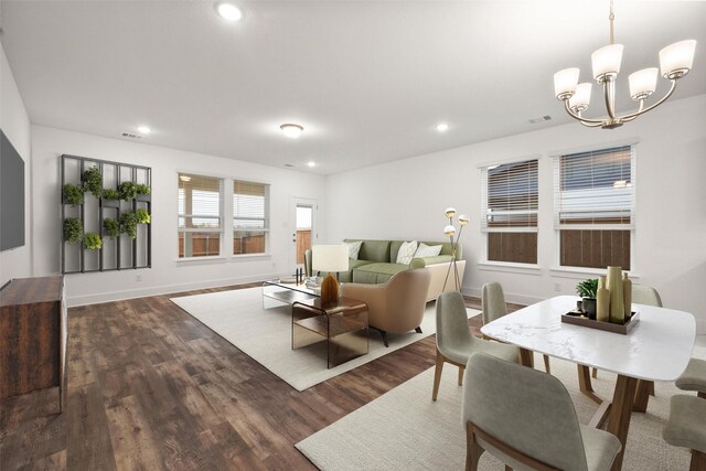 living room with dark wood-type flooring and a notable chandelier