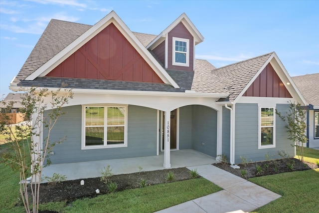 view of front of home featuring covered porch and a front lawn