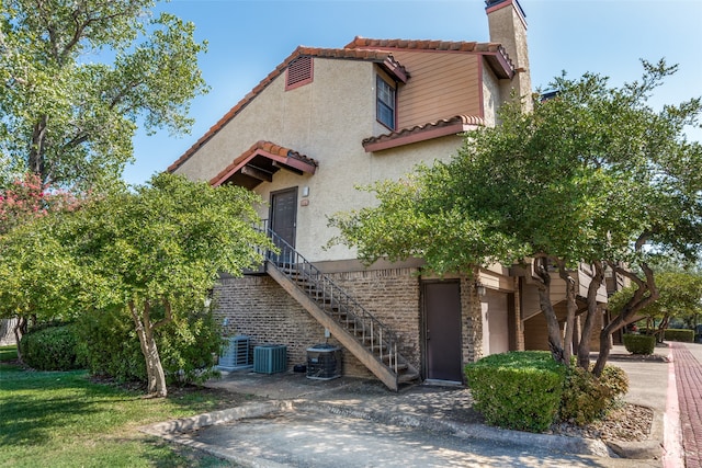 view of front of house with a garage and cooling unit