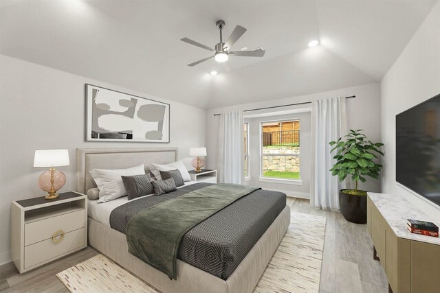 bedroom with ceiling fan, lofted ceiling, and light hardwood / wood-style floors