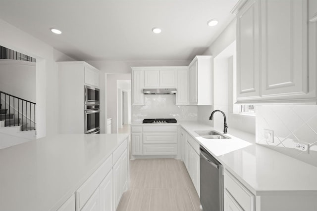 kitchen featuring tasteful backsplash, appliances with stainless steel finishes, sink, and white cabinets