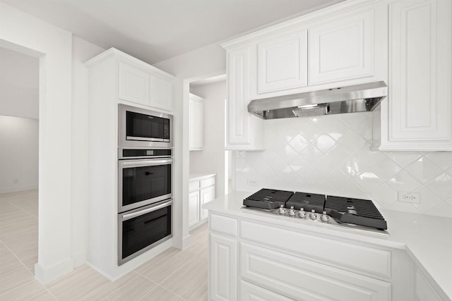 kitchen with backsplash, stainless steel appliances, ventilation hood, and white cabinets