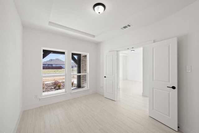 spare room featuring a raised ceiling