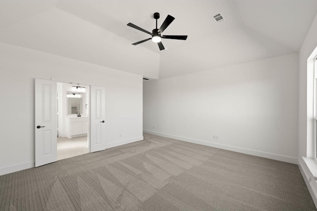 unfurnished bedroom featuring ceiling fan, ensuite bathroom, vaulted ceiling, and light carpet