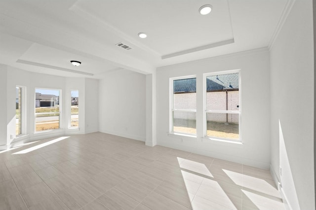 tiled empty room featuring a raised ceiling