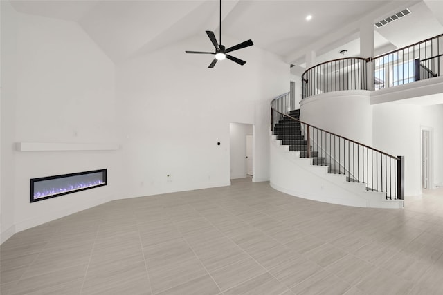 unfurnished living room with high vaulted ceiling and ceiling fan