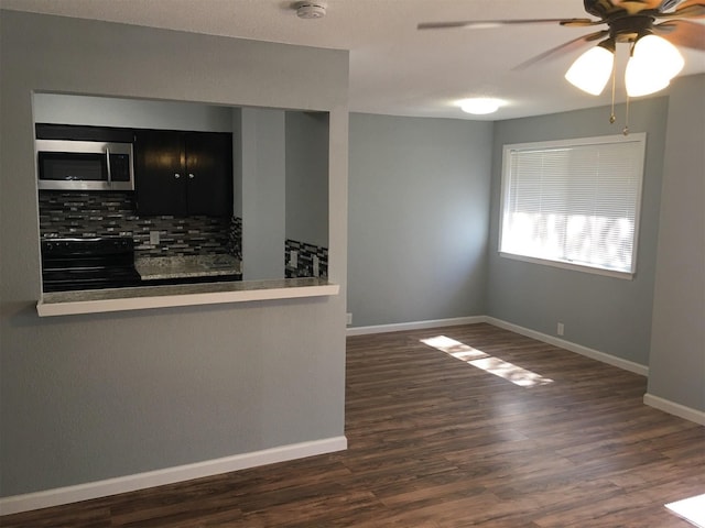 kitchen featuring electric range, dark wood-type flooring, ceiling fan, and tasteful backsplash