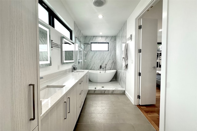 bathroom featuring tile walls, tile patterned flooring, vanity, and separate shower and tub