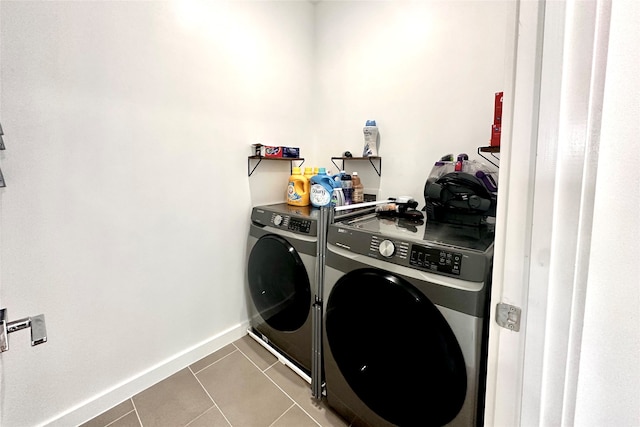 clothes washing area with tile patterned flooring and washer and dryer