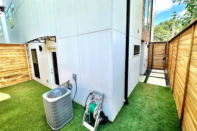 view of side of property featuring a yard and central air condition unit