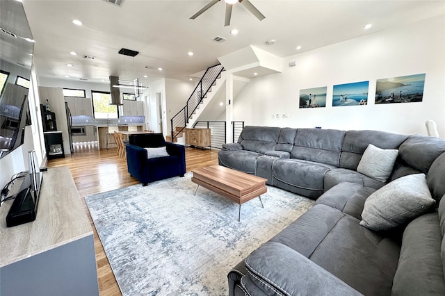 living room featuring light hardwood / wood-style flooring and ceiling fan