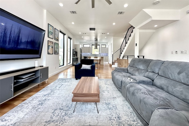 living room featuring ceiling fan and hardwood / wood-style floors