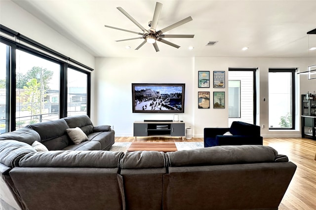 living room featuring light hardwood / wood-style floors and ceiling fan