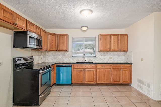 kitchen featuring decorative backsplash, light tile patterned flooring, sink, and stainless steel appliances