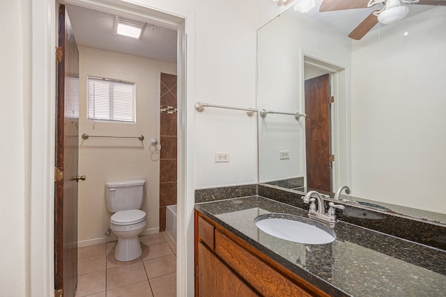 bathroom with ceiling fan, vanity, toilet, a textured ceiling, and tile patterned flooring