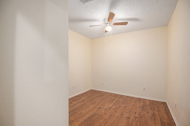 empty room with ceiling fan, hardwood / wood-style flooring, and a textured ceiling