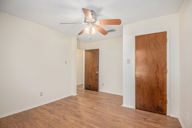 empty room with light wood-type flooring, a textured ceiling, and ceiling fan