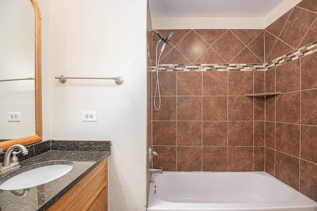 bathroom featuring a textured ceiling, tiled shower / bath combo, and vanity