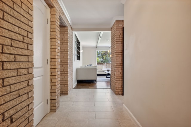 hall featuring light tile patterned flooring and ornamental molding