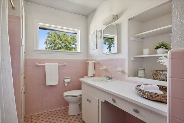 bathroom featuring vanity, tile walls, and toilet