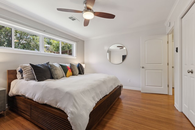 bedroom with hardwood / wood-style flooring, ceiling fan, and crown molding