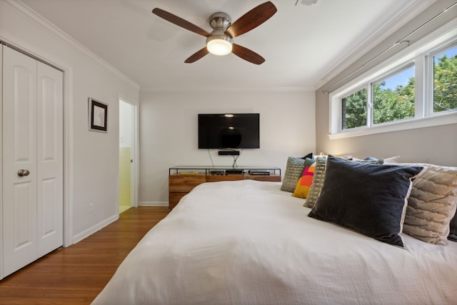 bedroom featuring crown molding, ceiling fan, a closet, and hardwood / wood-style floors