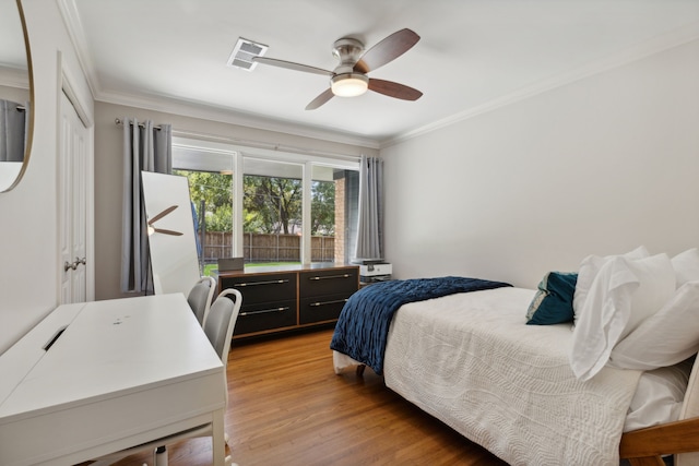 bedroom featuring light wood-type flooring, a closet, ceiling fan, and crown molding