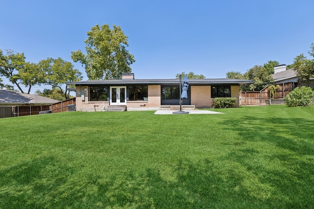 rear view of property featuring a yard and french doors