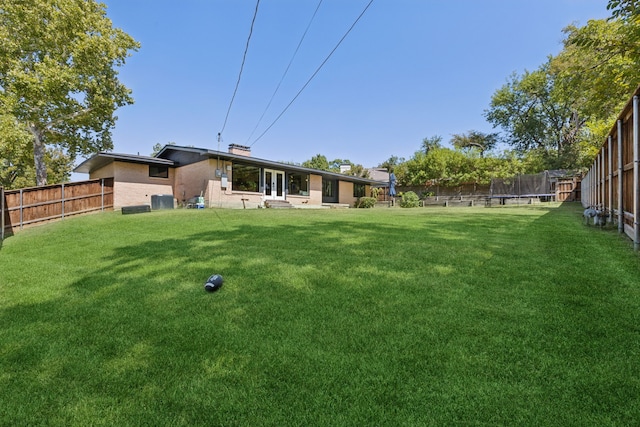 view of yard with central AC unit and a trampoline