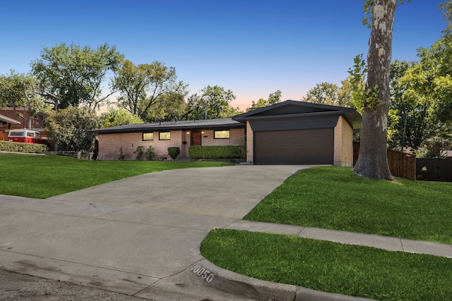 ranch-style home with a yard and a garage