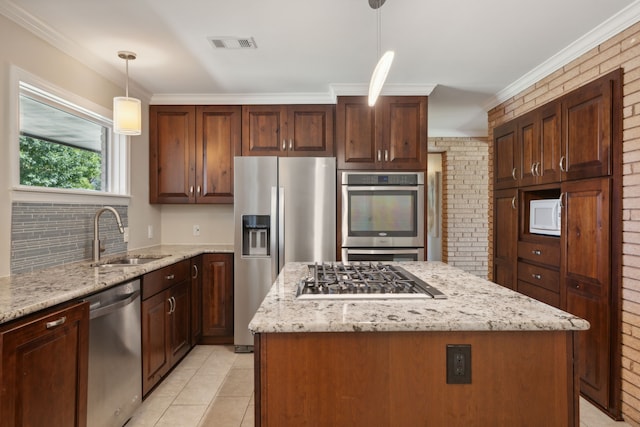 kitchen featuring decorative light fixtures, a center island, brick wall, and appliances with stainless steel finishes