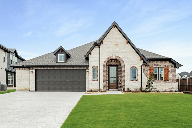 french country home featuring central AC, a garage, and a front lawn