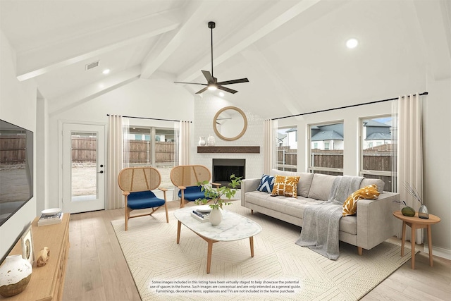 living room with plenty of natural light, light wood-type flooring, and a brick fireplace