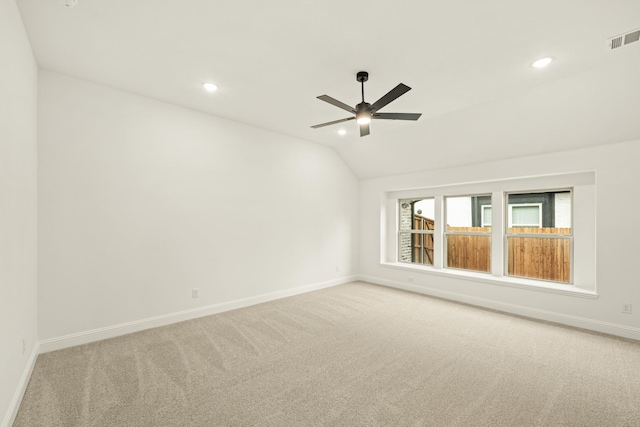 carpeted empty room with ceiling fan and lofted ceiling