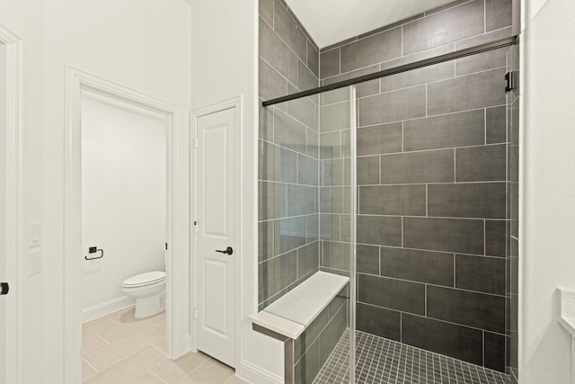 bathroom featuring a shower with shower door and toilet