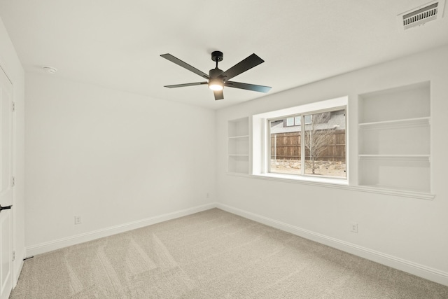 carpeted empty room with built in features and ceiling fan