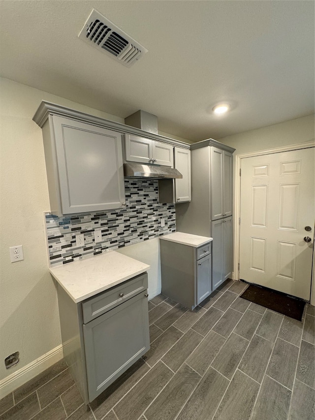 kitchen with gray cabinetry and tasteful backsplash