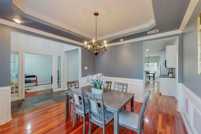 dining room with a chandelier, crown molding, and dark hardwood / wood-style flooring