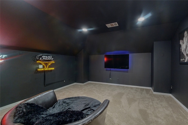 carpeted home theater room with lofted ceiling