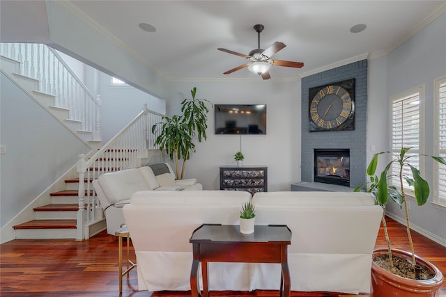 living room featuring a fireplace, ornamental molding, dark hardwood / wood-style floors, and ceiling fan