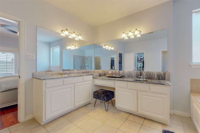 bathroom featuring ceiling fan, tile patterned flooring, a shower with shower door, and vanity