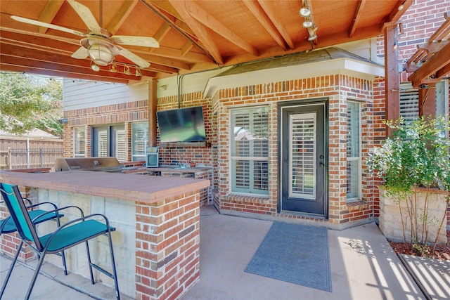 view of patio featuring ceiling fan, grilling area, exterior bar, and exterior kitchen