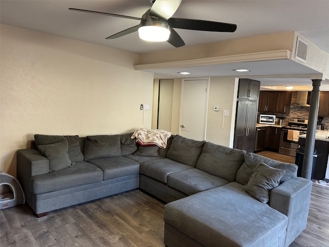 living room with ceiling fan and dark hardwood / wood-style flooring