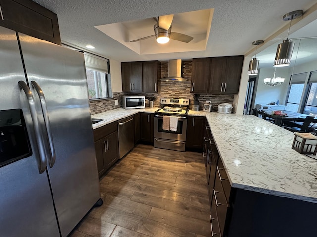 311 Oak Shadow Cir, Bedford, TX 76021 - kitchen with appliances with stainless steel finishes, wall chimney exhaust hood, a peninsula, dark brown cabinets, and tasteful backsplash